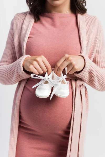 孕妇抱着白色婴儿靴的剪影 — 图库照片