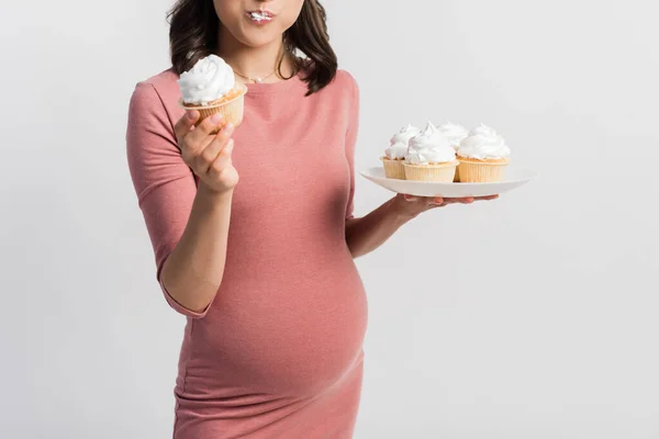 Vue Recadrée Femme Enceinte Tenant Plaque Tout Mangeant Cupcake Isolé — Photo