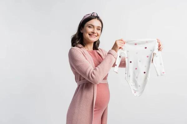 Pleased Pregnant Woman Headband Holding Baby Romper Isolated White — Stock Photo, Image