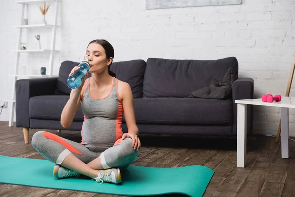 Těhotná Žena Sedí Fitness Podložce Při Pití Vody Sportovní Láhve — Stock fotografie