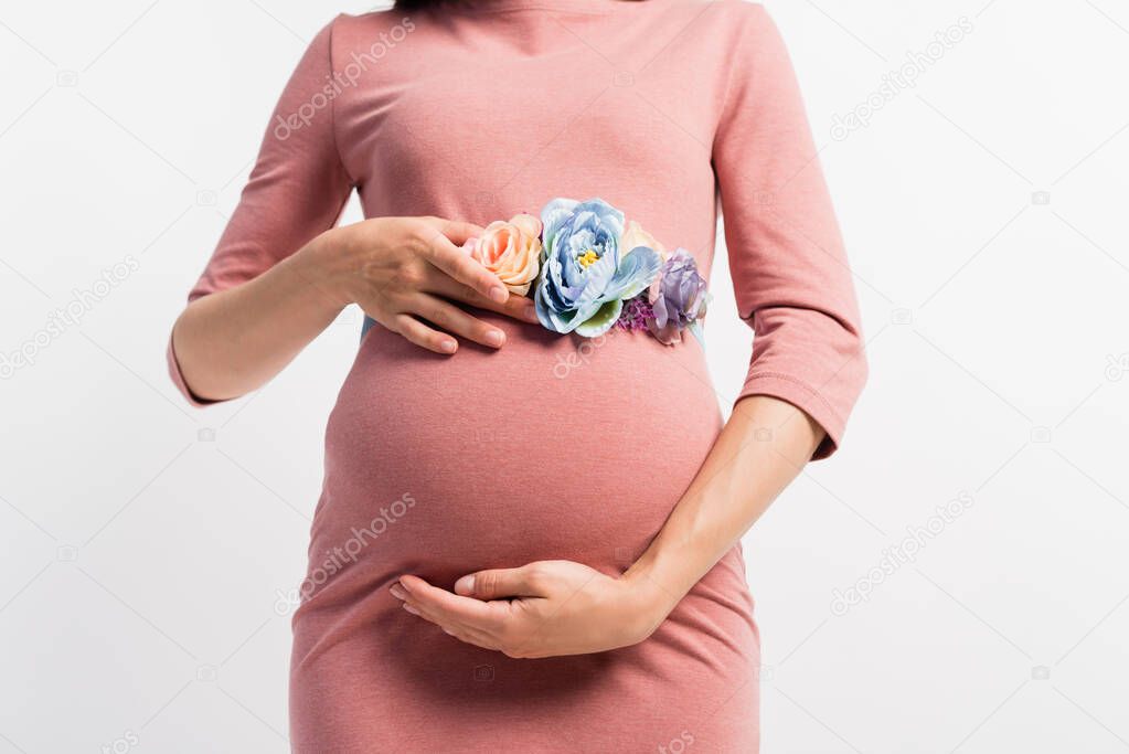cropped view of pregnant woman with floral belt touching tummy isolated on white 