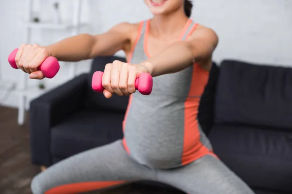 在家用粉色哑铃锻炼的孕妇的选择性焦点 — 图库照片