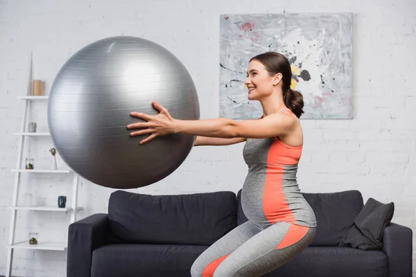 Hamile Kadın Oturma Odasında Fitness Topuyla Çömeliyor — Stok fotoğraf