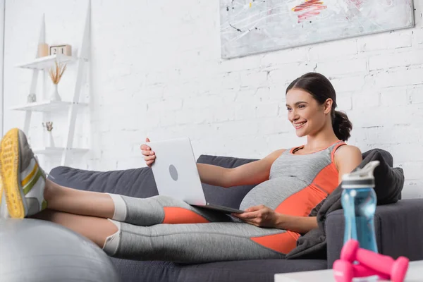 Mulher Esportiva Grávida Olhando Para Laptop Perto Garrafa Esportes Halteres — Fotografia de Stock