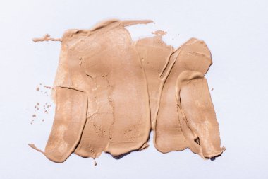 Beyaz arkaplanda bej yüz temel fırça darbelerinin üst görünümü