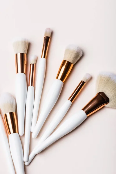 Top View White Golden Cosmetic Brushes Set Beige Background — Stock Photo, Image