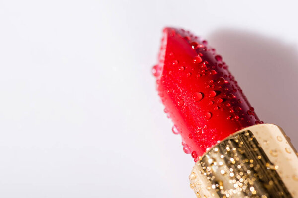 крупным планом вид красной влажной помады на белом фоне