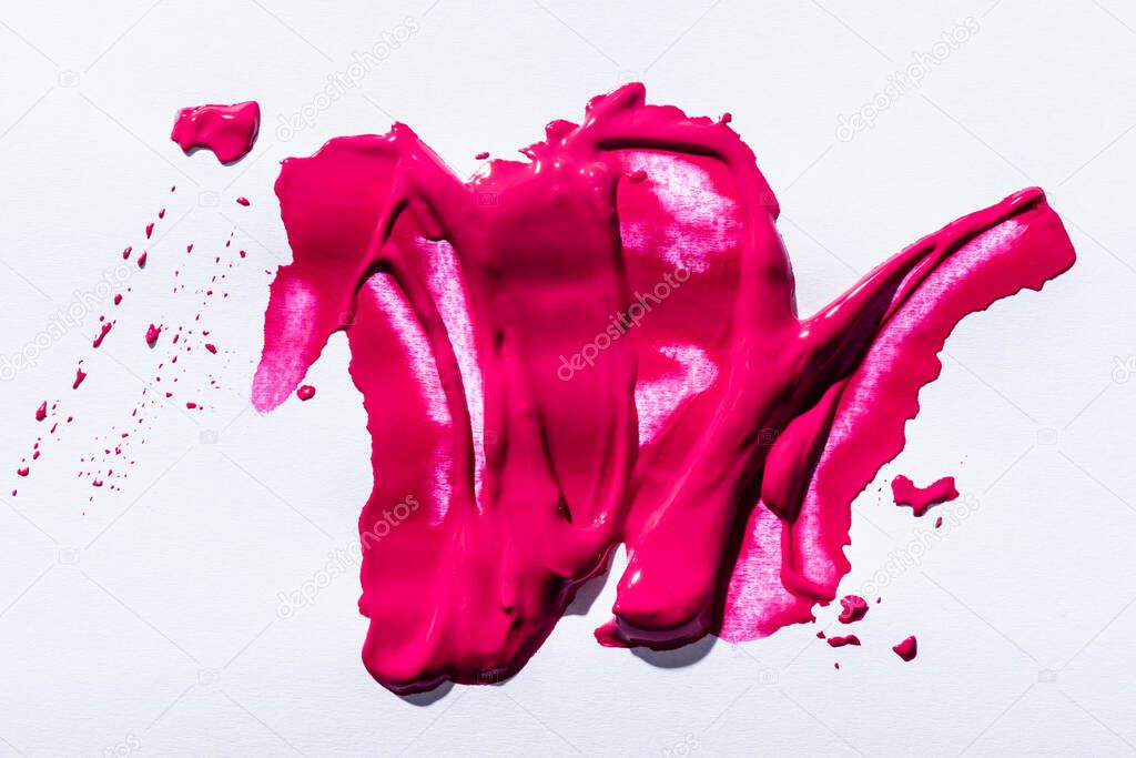 top view of pink lipstick brushstrokes on white background