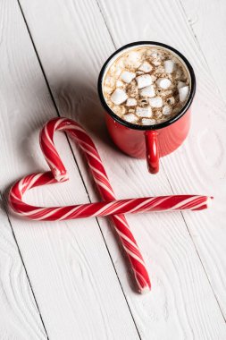 Noel 'e yakın kırmızı bir fincan kakao aşk sembolü şeklinde şeker kamışları.
