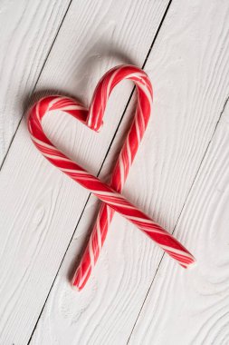 Noel şekerlerinin tahta arka planda aşk sembolü şeklinde üst görünümü