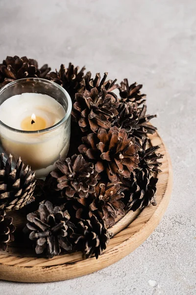 Scented Candle Pine Cones Wooden Plate Textured Grey Background — Stock Photo, Image