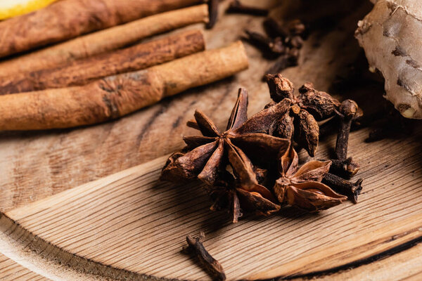Close up of anise stars, carnation and cinnamon sticks on wooden background