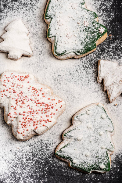 Close up view of decorated gingerbread cookies covered with sugar powder