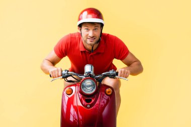 Kırmızı scooter 'la sarı kasklı heyecanlı adam.