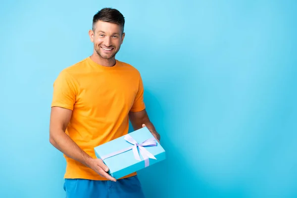 Homme Heureux Shirt Tenant Boîte Cadeau Enveloppé Sur Bleu — Photo