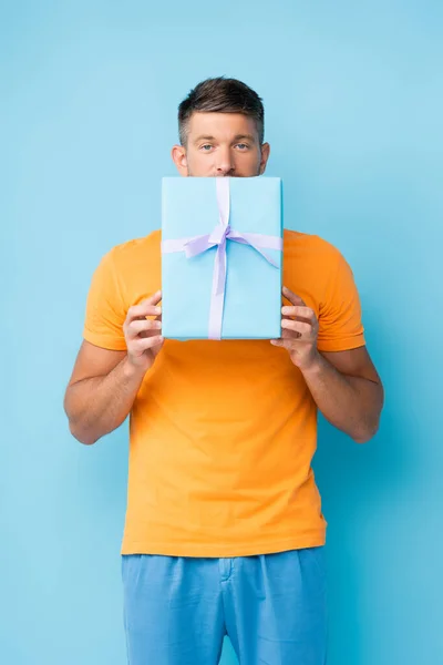 Homme Shirt Couvrant Bouche Avec Boîte Cadeau Enveloppée Sur Bleu — Photo