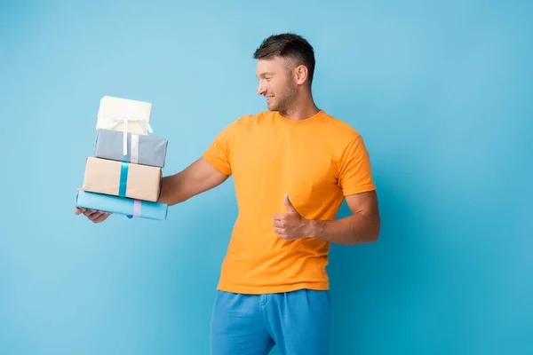 Man Shirt Holding Wrapped Presents Showing Thumb Blue — Stock Photo, Image