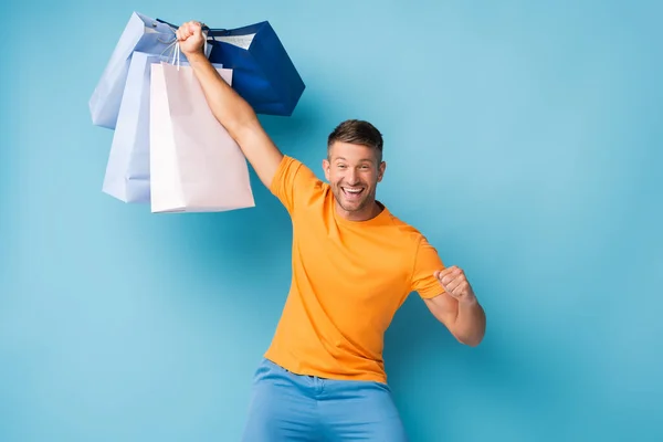 Excited Man Shirt Holding Shopping Bags Blue — Stock Photo, Image