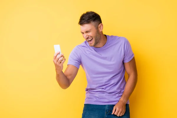 Hombre Feliz Sosteniendo Teléfono Inteligente Riendo Amarillo — Foto de Stock