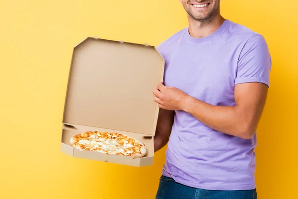 幸せそうな男が黄色いピザを持って箱を持っている姿を切り取られました — ストック写真