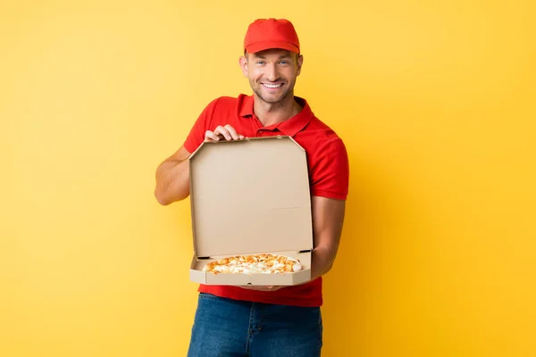Kırmızı Şapkalı Neşeli Teslimatçı Elinde Leziz Pizzayla Sarıda Bekliyor — Stok fotoğraf