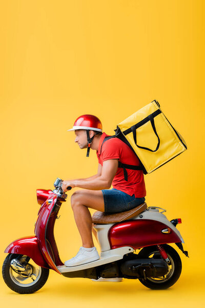 side view of delivery man with backpack riding scooter on yellow
