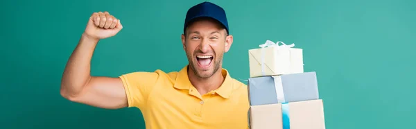 Excited Delivery Man Cap Holding Wrapped Presents Blue Banner — Stock Photo, Image