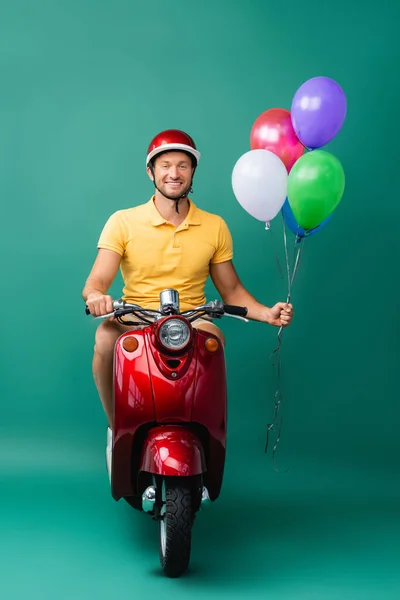 Hombre Entrega Feliz Casco Montar Scooter Rojo Mientras Sostiene Globos — Foto de Stock