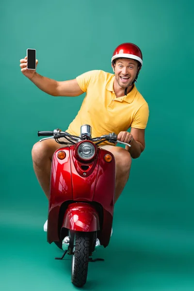 Aufgeregter Zusteller Mit Helm Fährt Roller Und Hält Smartphone Mit — Stockfoto