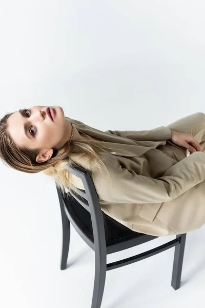 Modelo Elegante Terno Bege Posando Cadeira Madeira Branco — Fotografia de Stock