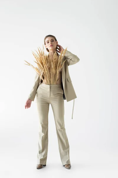 Стильная Женщина Бежевом Костюме Пшеничными Шипами Позирующими Белом — стоковое фото