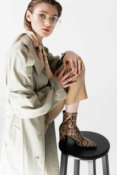 Trençkotlu Atkılı Modaya Uygun Genç Kadın Beyaz Sandalyenin Yanında Poz — Stok fotoğraf