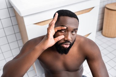 afro-american man trying not sleeping and holding eyelids clipart
