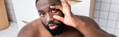panoramic shot of afro-american man trying not sleeping and holding eyelids clipart