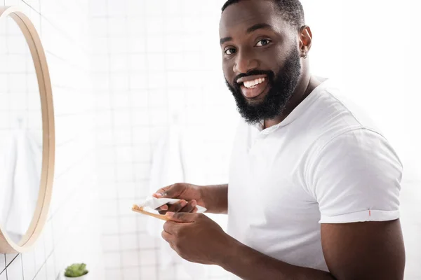 Χαμογελαστός Αφρο Αμερικανός Άντρας Βγάζει Οδοντόκρεμα Και Κοιτάζει Την Κάμερα — Φωτογραφία Αρχείου