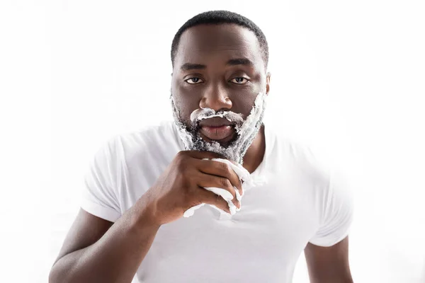 顔をカメラで見て泡を剃っているアフリカ系アメリカ人男性は — ストック写真