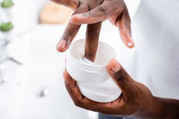 обрезанный вид афро-американского человека с использованием косметического крема