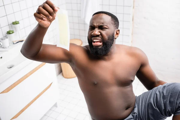 Hombre Afro Americano Mirando Tiras Cera Con Asco — Foto de Stock