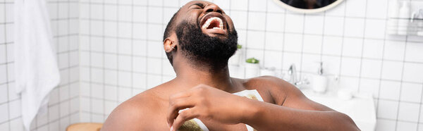 panoramic shot of afro-american man tearing off wax strips and screaming from pain