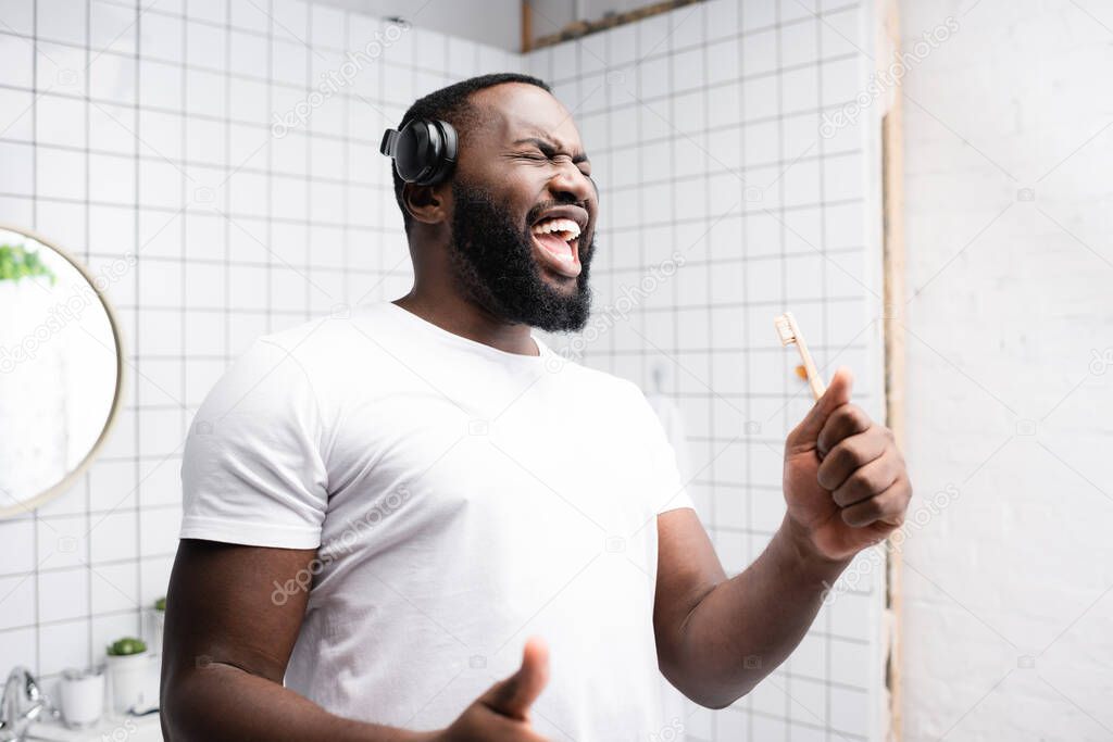 afro-american man with headphones singing in toothbrush