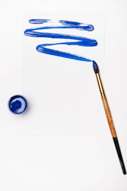 top view of blue paint brushstroke and paintbrush on white background clipart