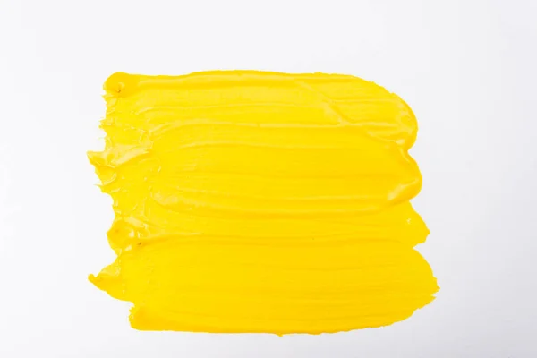 top view of abstract colorful yellow paint brushstrokes on white background