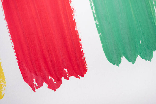 top view of abstract colorful green and red paint brushstrokes on white background