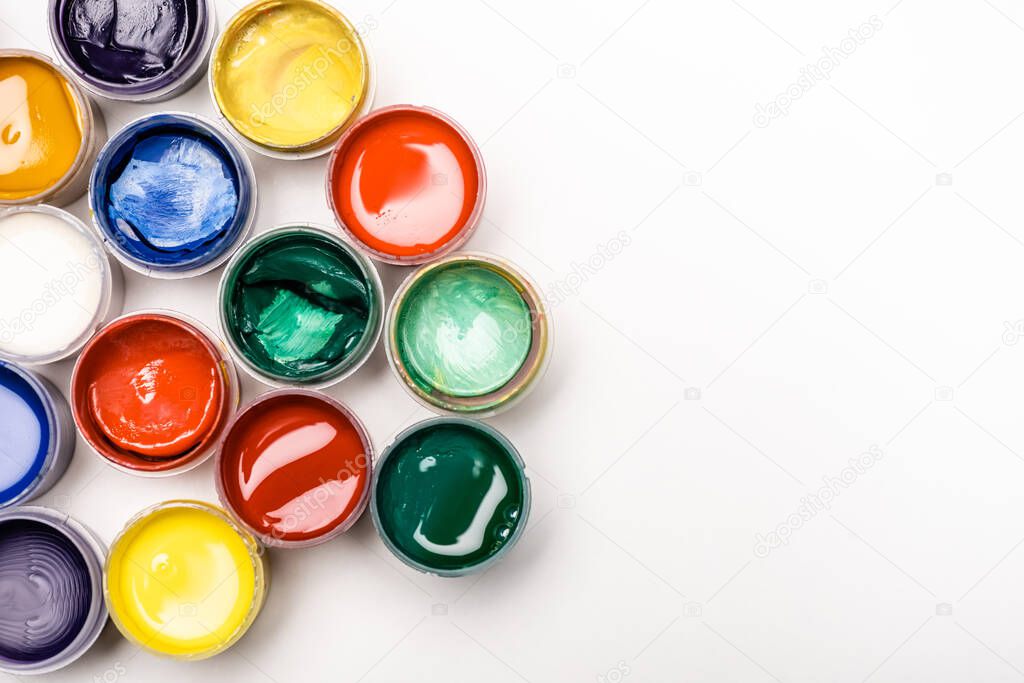 top view of colorful Gouache paints on white background