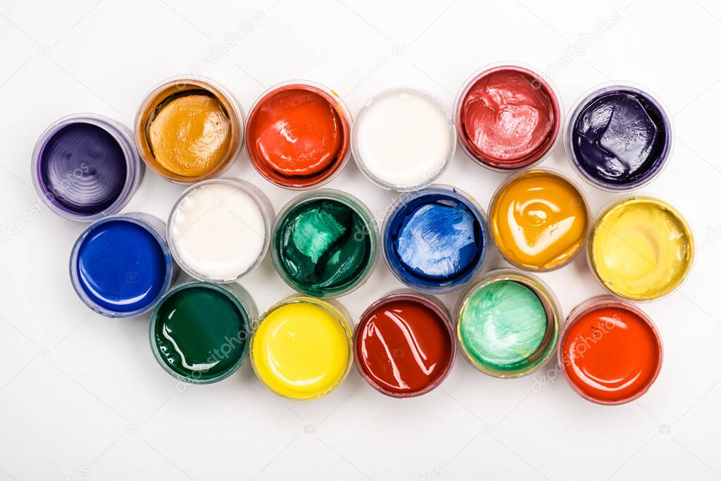 top view of colorful Gouache paints on white background