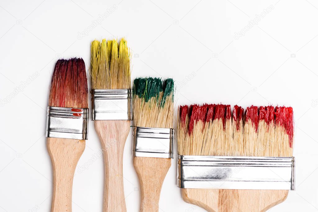 top view of dirty paintbrushes on white background