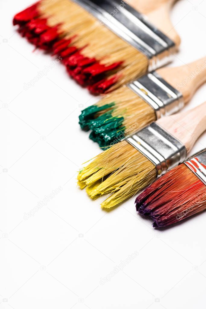 close up view of dirty paintbrushes on white background