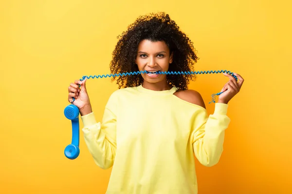 Lockigt Afrikansk Amerikansk Kvinna Bita Kabel Vintage Telefon Gul — Stockfoto