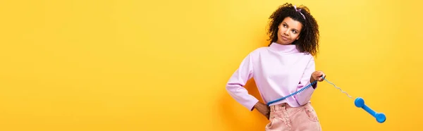 Displeased African American Woman Holding Blue Retro Phone Yellow Banner — Stock Photo, Image