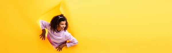 Curious African American Woman Looking Away Hole Ripped Paper Smiling — Stock Photo, Image